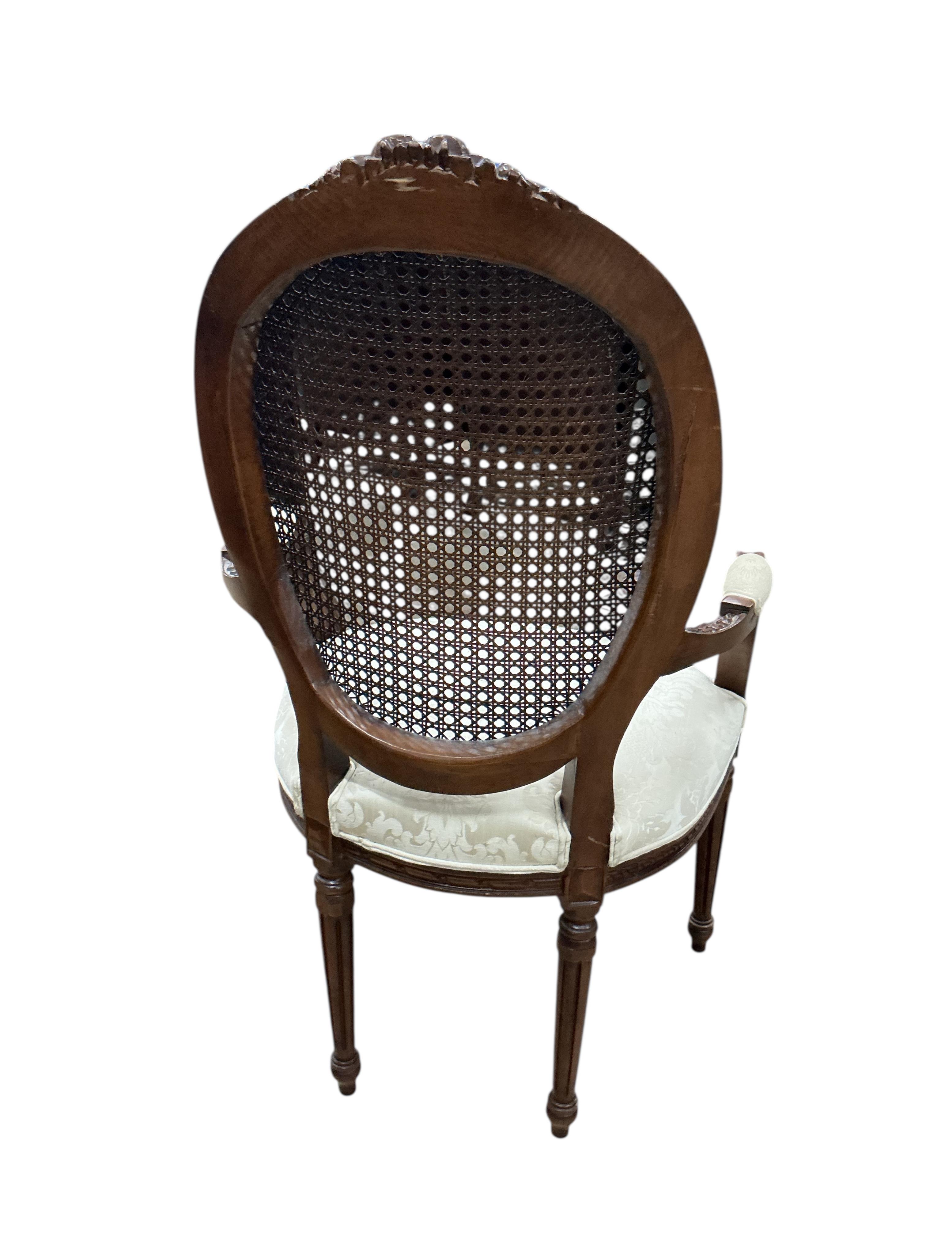 An early 20th century French carved caned mahogany elbow chair in Louis XVI style, width 61cm, depth 53cm, height 112cm